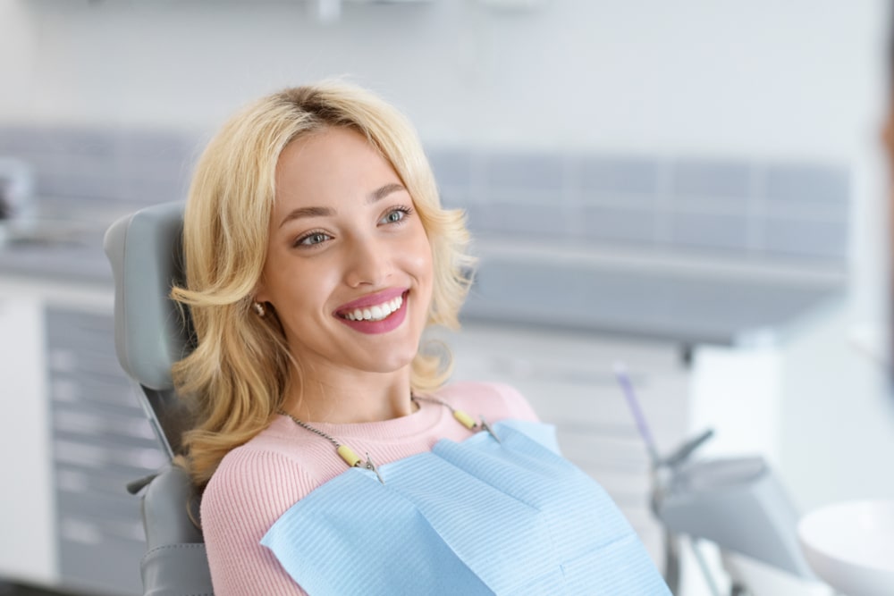Relaxed blonde woman smiling at dental clinic