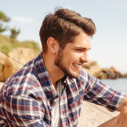 Smiling young man using smartphone