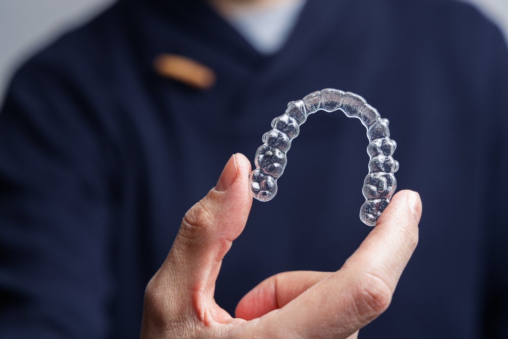A person holding part of Clear Aligners for Orthodontics in their hand