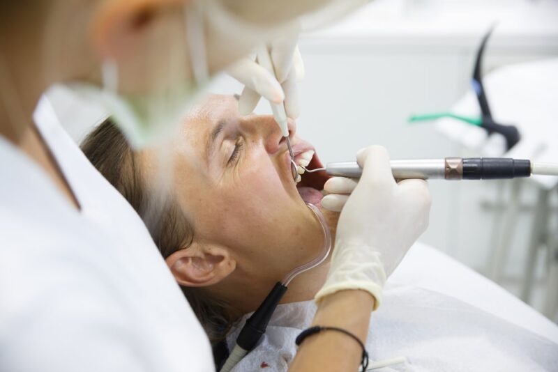 Woman getting her gum pocket depth measured with periodontal probe