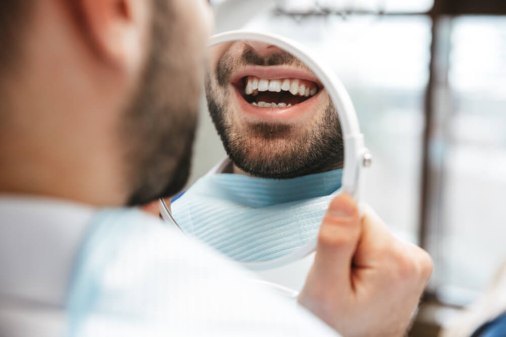 happy young man sitting in medical dentist cente