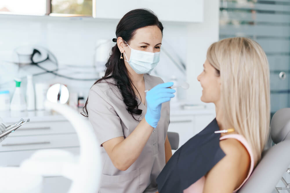 Female Dentist examine and discussing with happy patient
