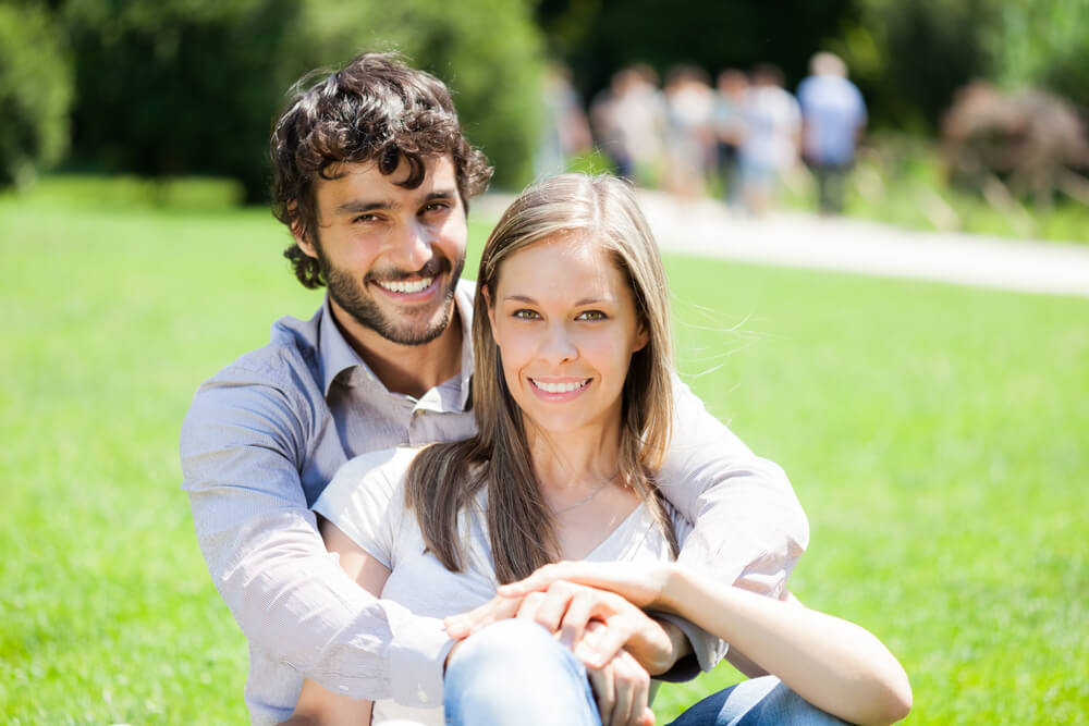 Young happy couple sitting in a park