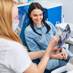 Cheerful woman sitting in dentistry chair with dentist