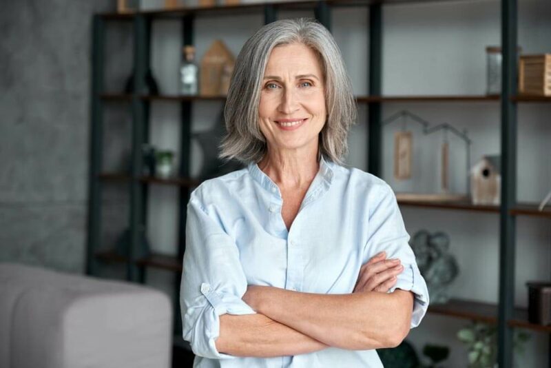 smiling middle aged woman standing with arms crossed