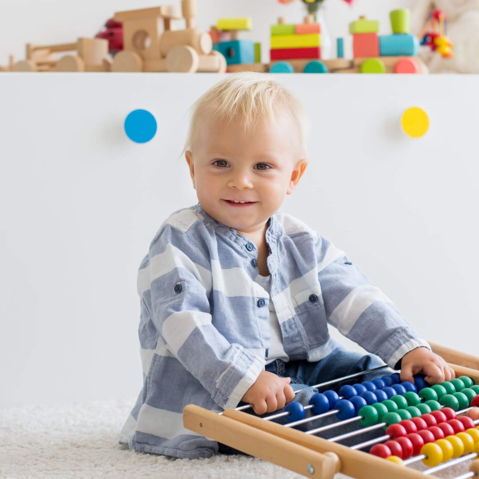 Cute little baby boy playing with abacus at home
