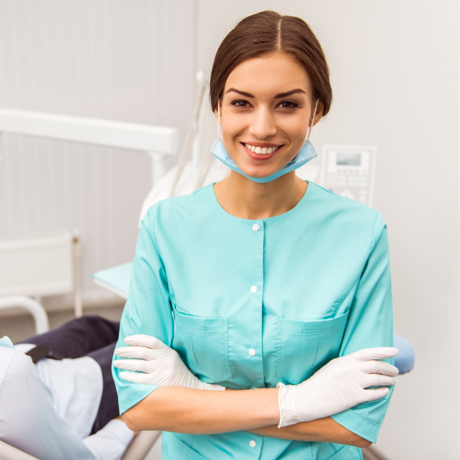 smiling young dentist with folded hands