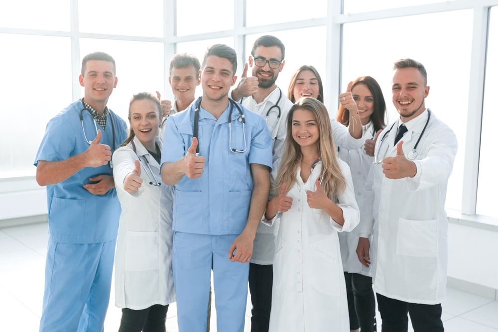 diverse medical professionals giving a thumbs up