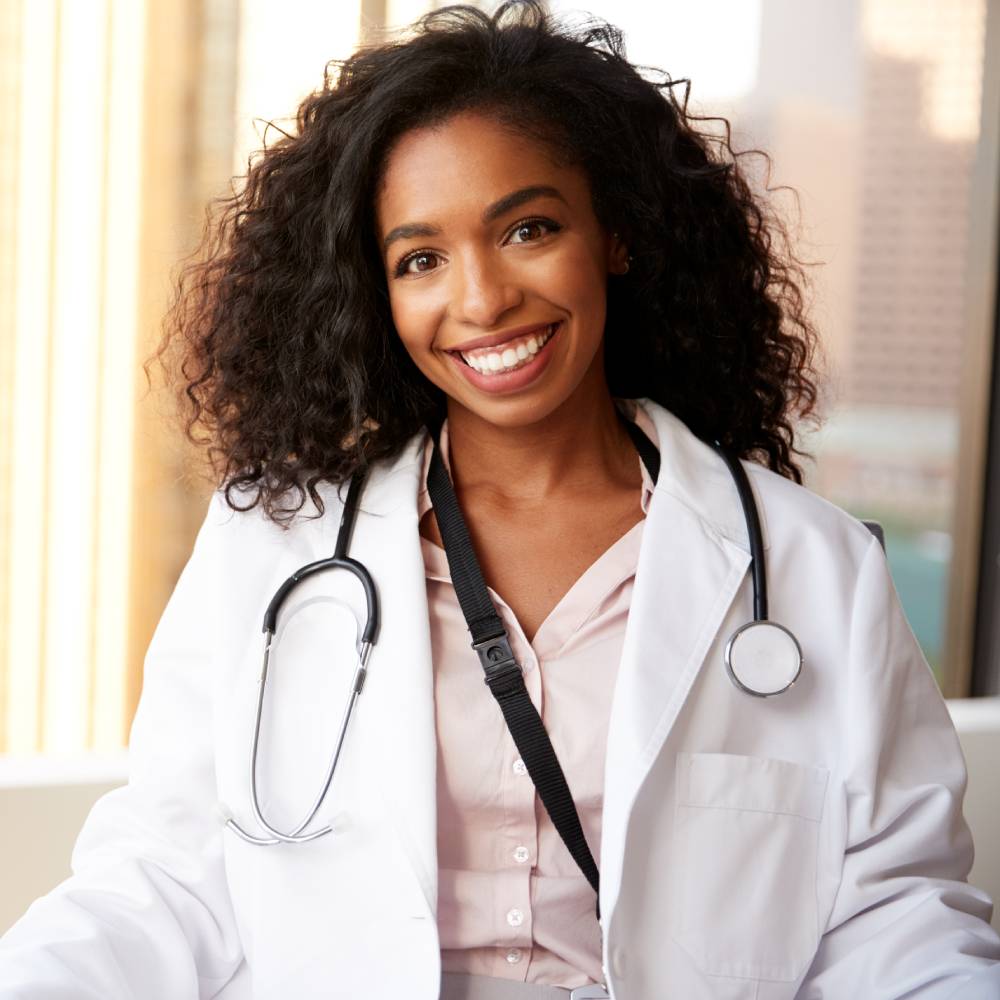 Smiling Female Doctor Wearing White Coat With Stethoscope