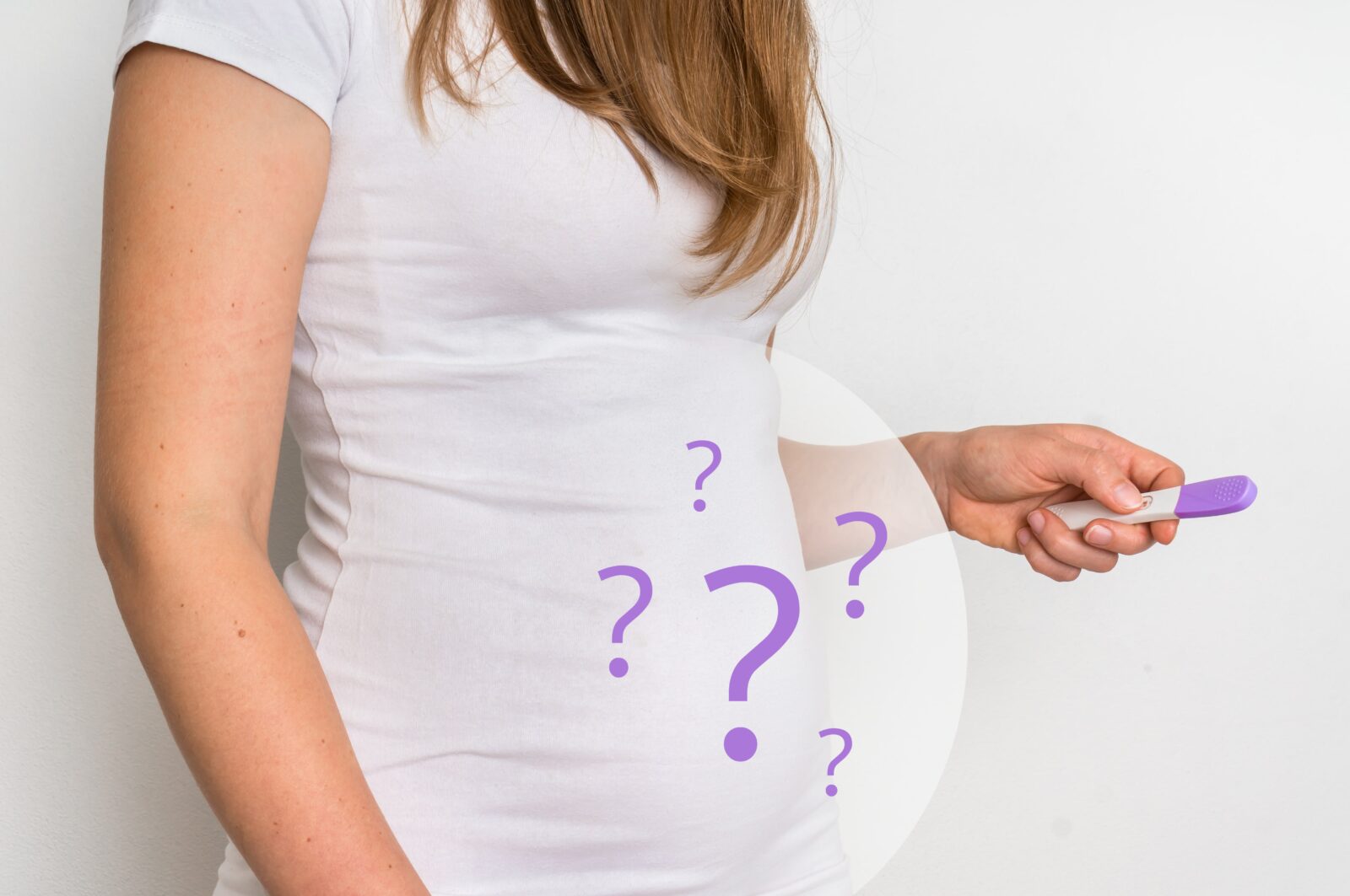 woman holding pregnancy test with question marks on her belly