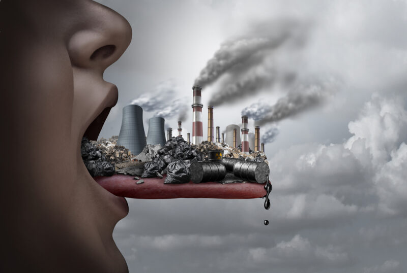 Toxic pollutants inside the human body and eating pollutants as an open mouth ingesting industrial toxins