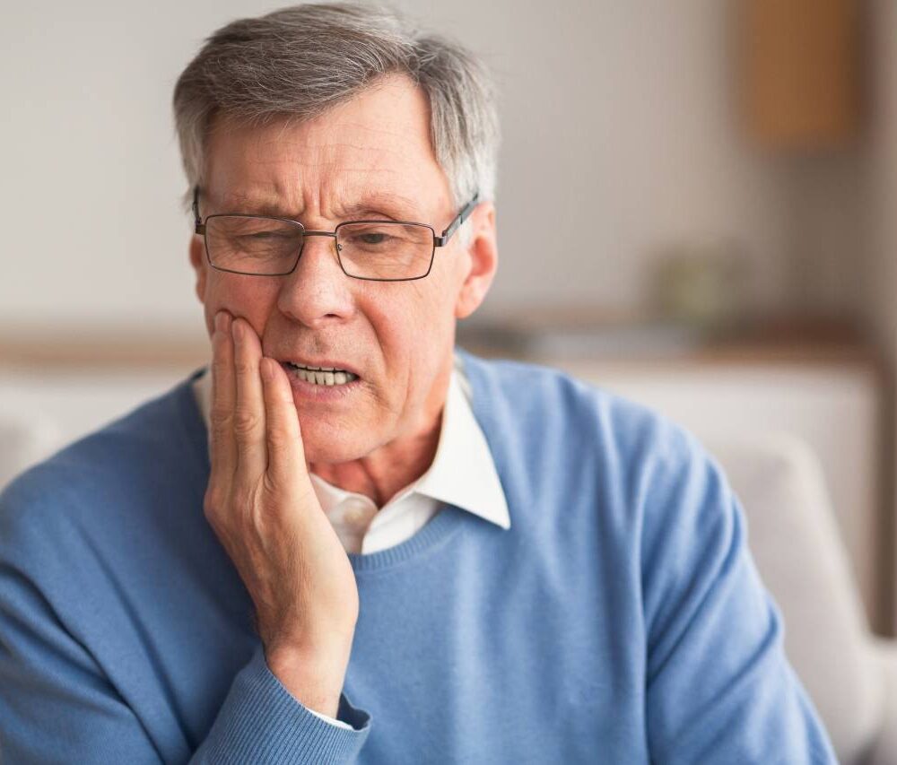 Elderly Man Having Toothache Touching Cheek