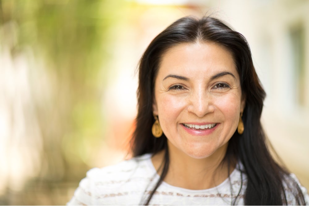 Beautiful middle age Hispanic woman smiling outside