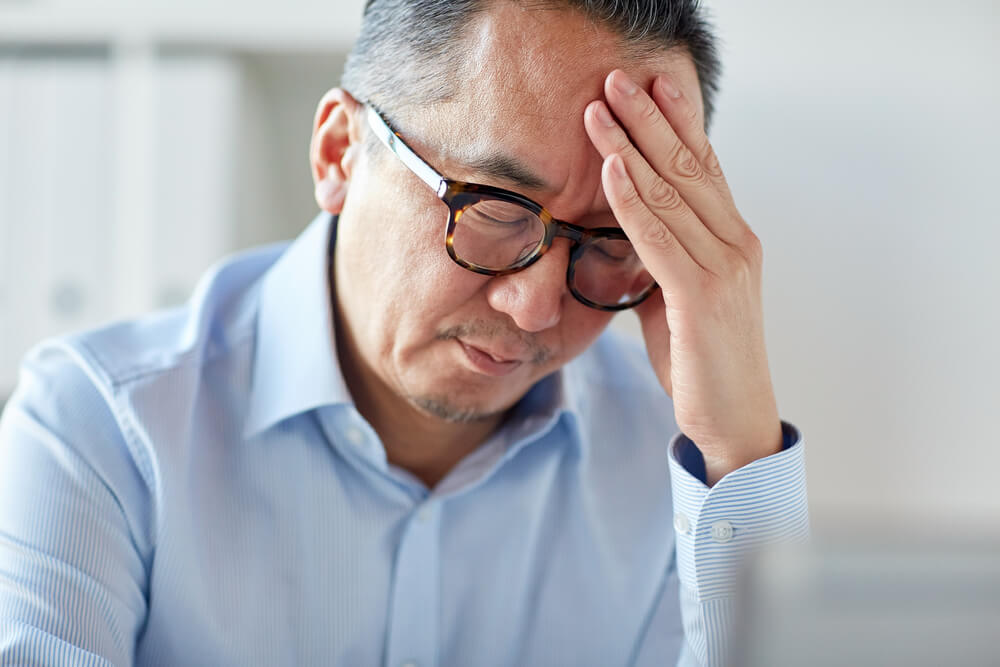 tired businessman in eyeglasses suffering from headache