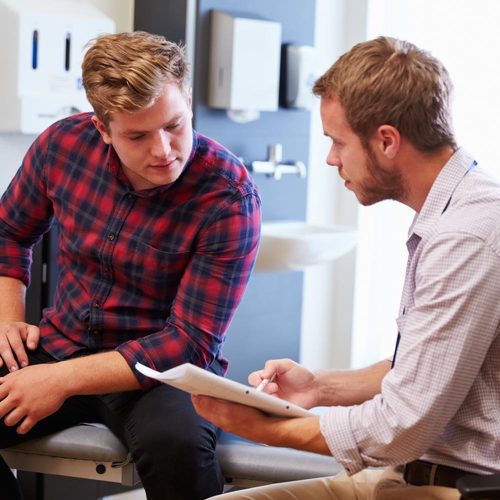 Male Patient And Doctor Have Consultation In Hospital