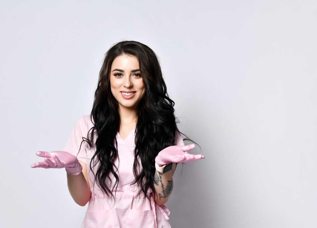 girl in pink scrubs and latex gloves posing
