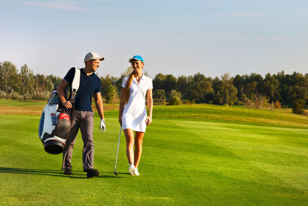 Young sportive couple playing golf