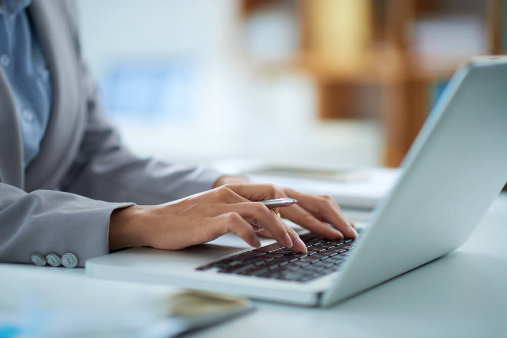 Hands of lady working on laptop