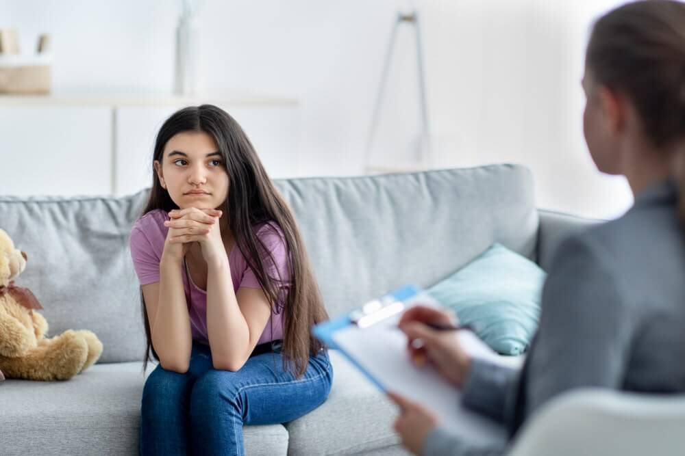 Psychologist and teen girl participating in individual counseling