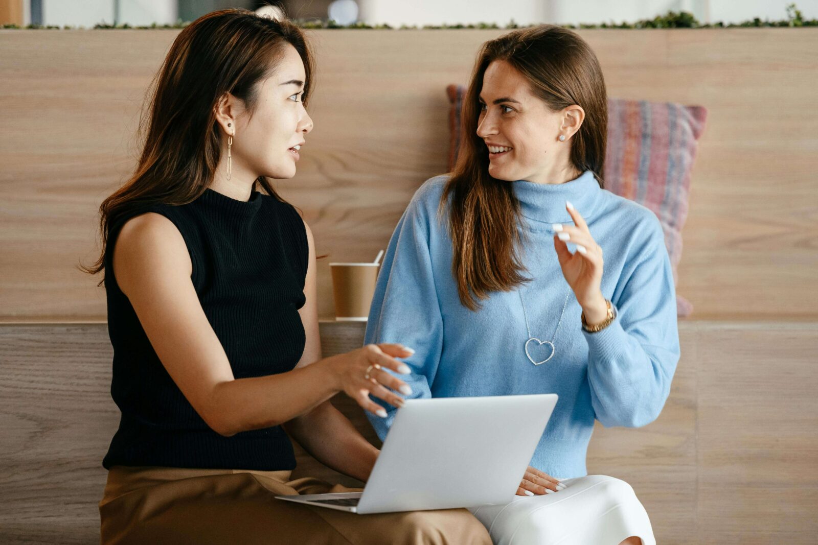 Two young women discuss how to refer a client to Transitions Counseling