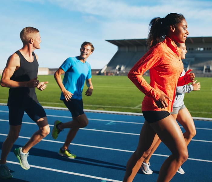 Fit men and women running on a race track
