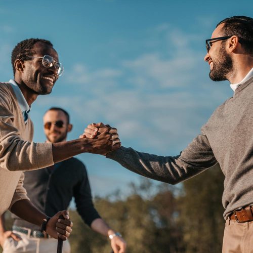 happy stylish friends shaking hands