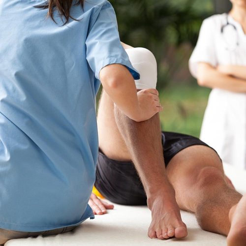 physiotherapist helping to exercise the patient injured knee