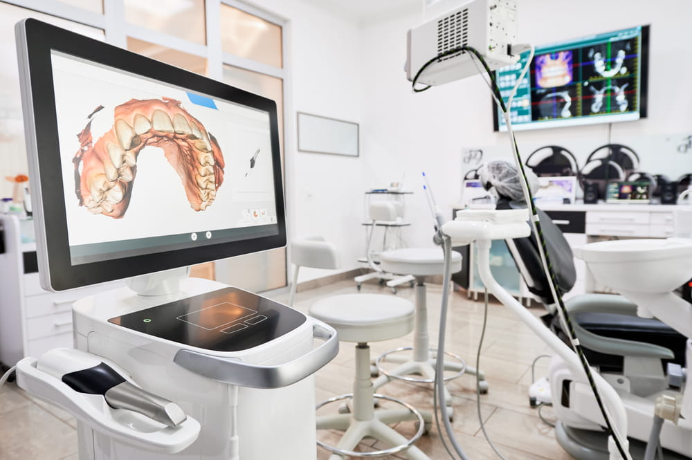 Interior of dental office with modern equipment and dental intraoral scanner with teeth on display, medical system for intraoral scanning.
