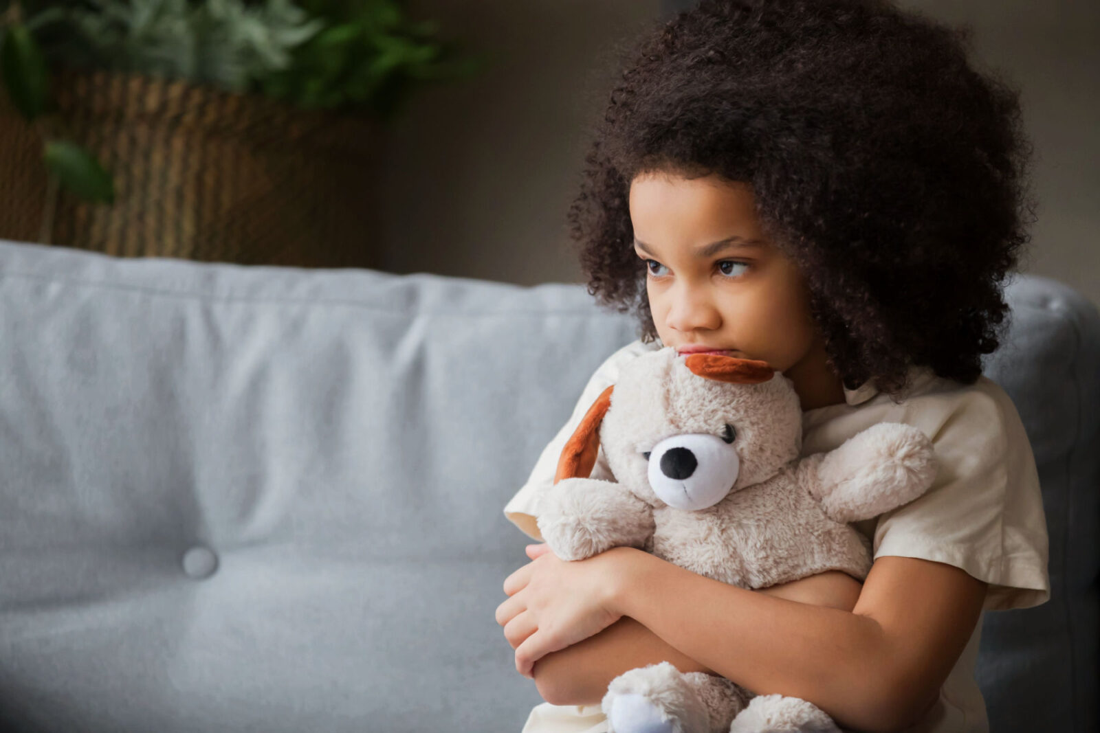upset little girl holding teddy bear that might benefit from individual and family therapy