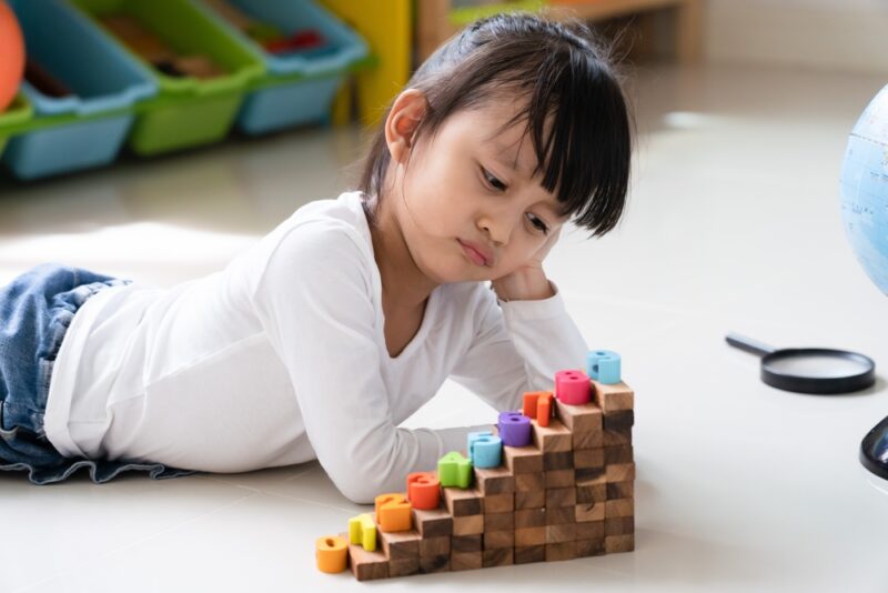 Asian 4 years old feeling bored while she play alone at home, concept of social skill, friendship and problem of mental health in young people.