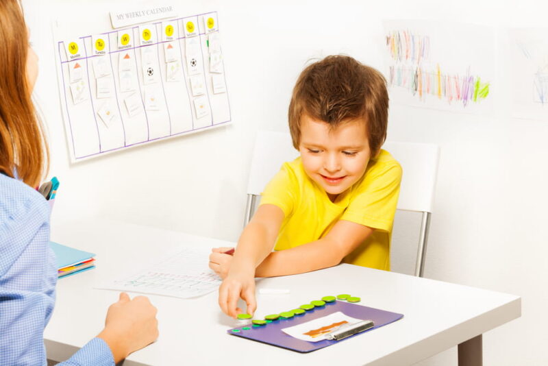 Smiling boy puts coins during developing game