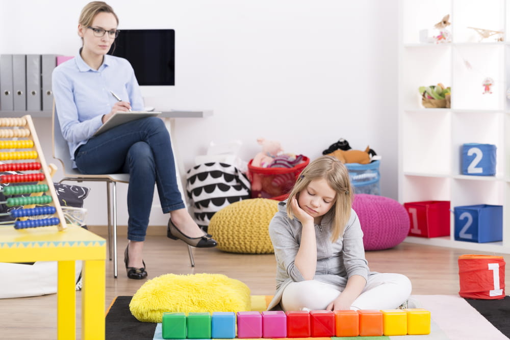 Female psychologist testing young girl with Asperger's syndrome symptoms