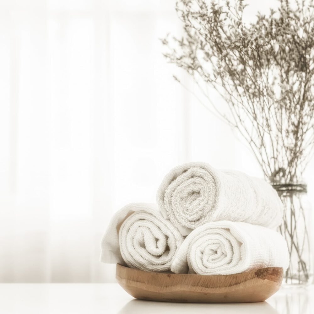 Towels on wood plate with copy space blurred bathroom