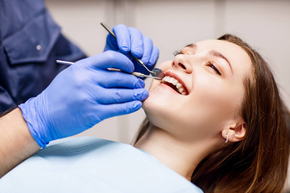 Dentist check-up teeth to young woman patient