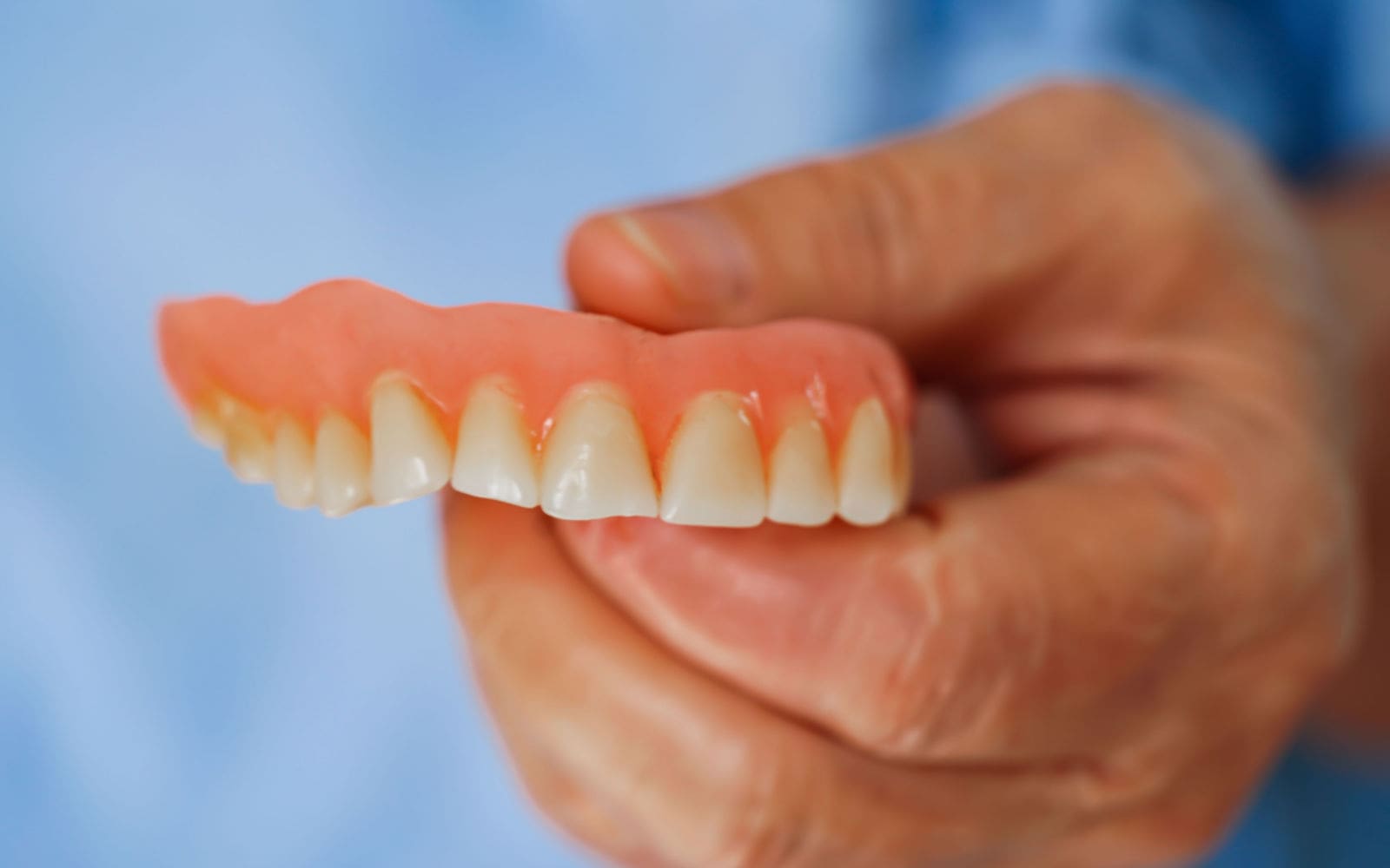 Close Up Image of Person Holding Dentures