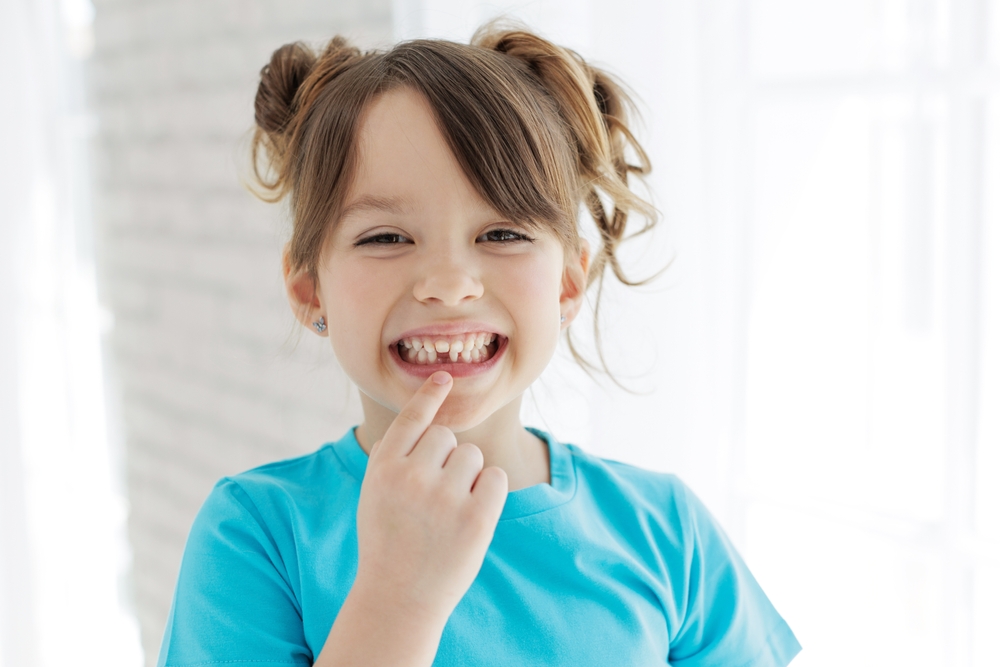 The kid lost a tooth. Baby without a tooth. Portrait of a little girl no tooth. High quality photo