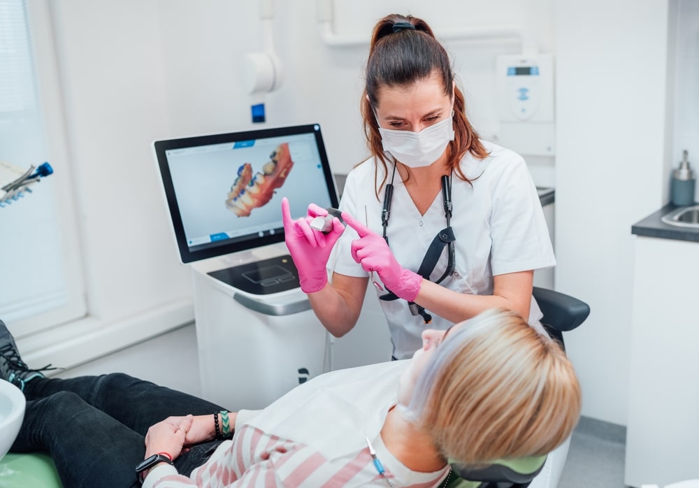 Dentist female doctor in uniform using intraoral 3D dental scanner Machine for clear aligners production
