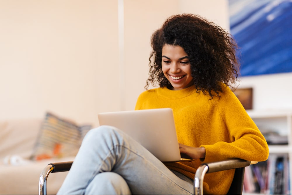 woman using laptop while sitting on chair