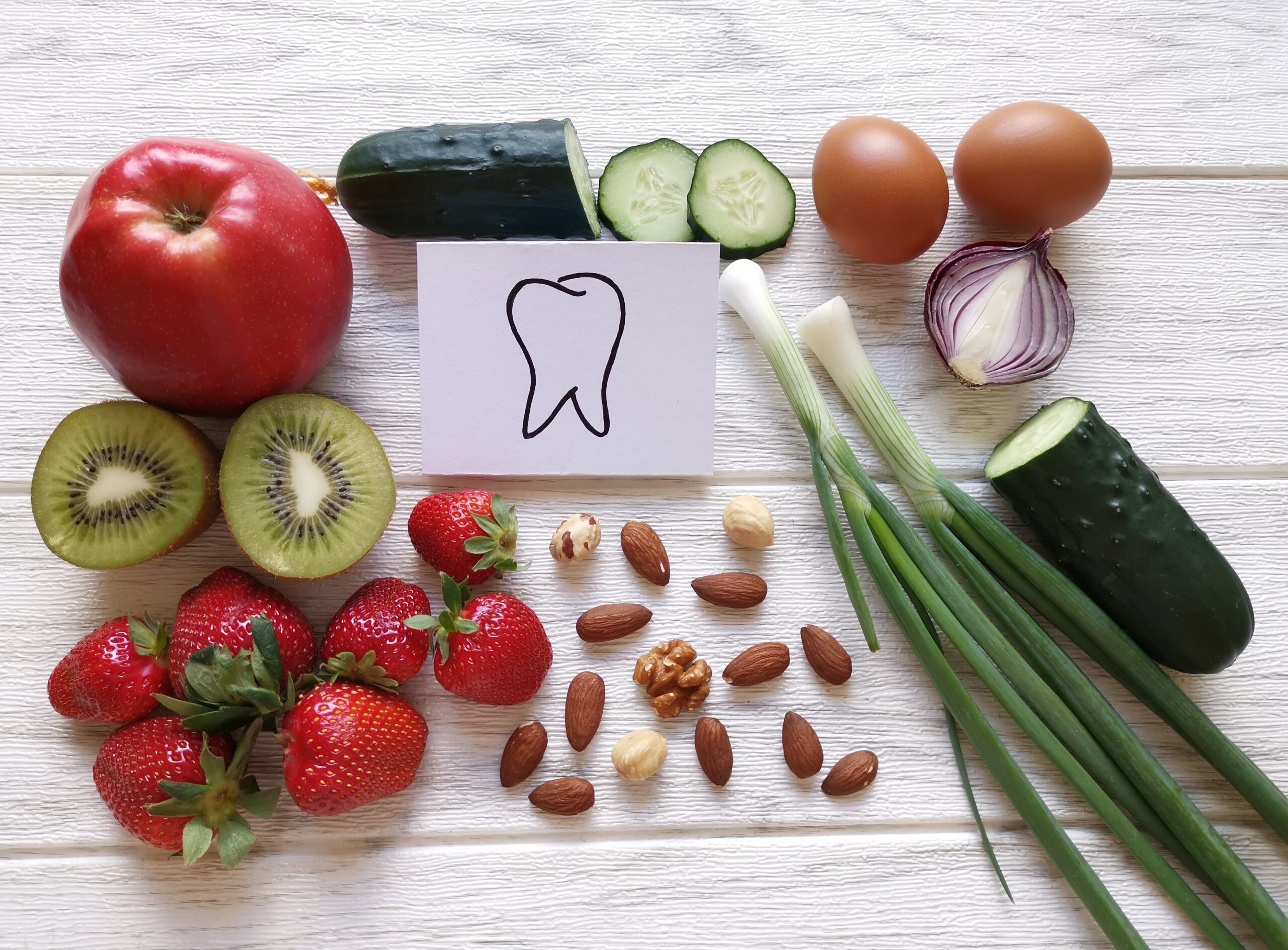 Assortment of food for healthy teeth and healthy smile. Various food for stronger whiter teeth. Best food for oral and gum health. Concept of dental nutrition. Strawberry, kiwi, egg, apple, almond...