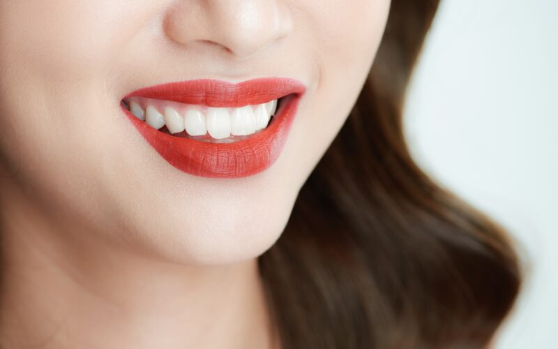 bottom half of woman's face smiling with lipstick