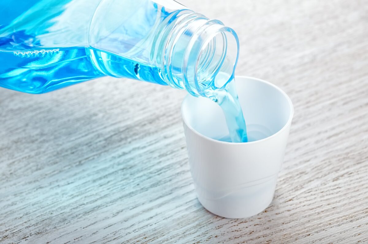 closeup of mouthwash being poured into a cup