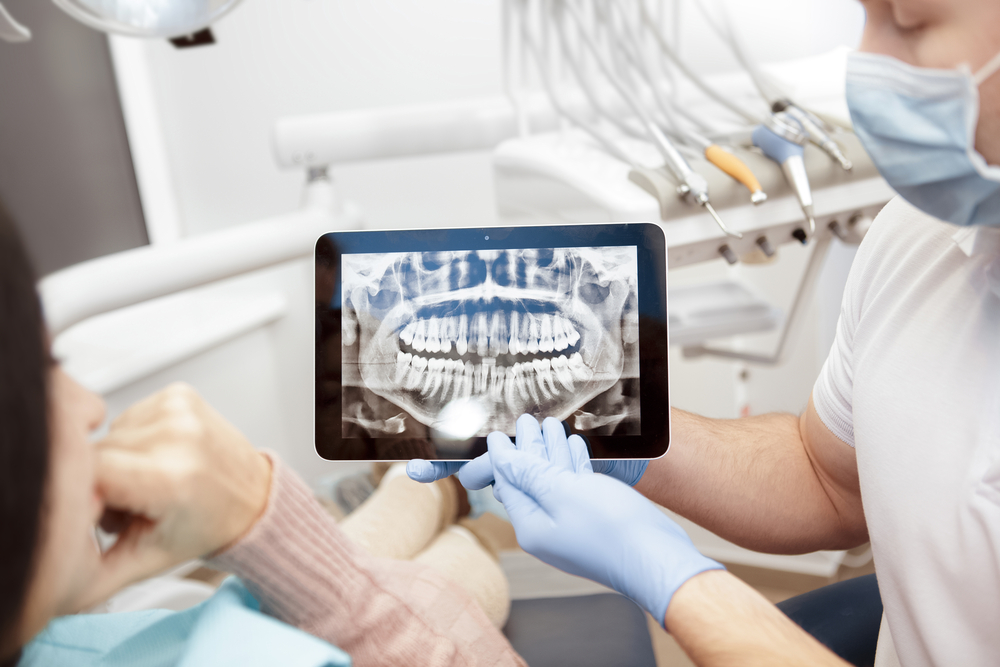 dentist showing digital teeth x-rays