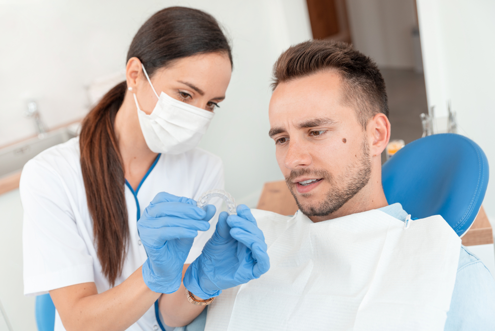 Dentist shows invisible braces aligner. Dental consultation in an orthodontic clinic