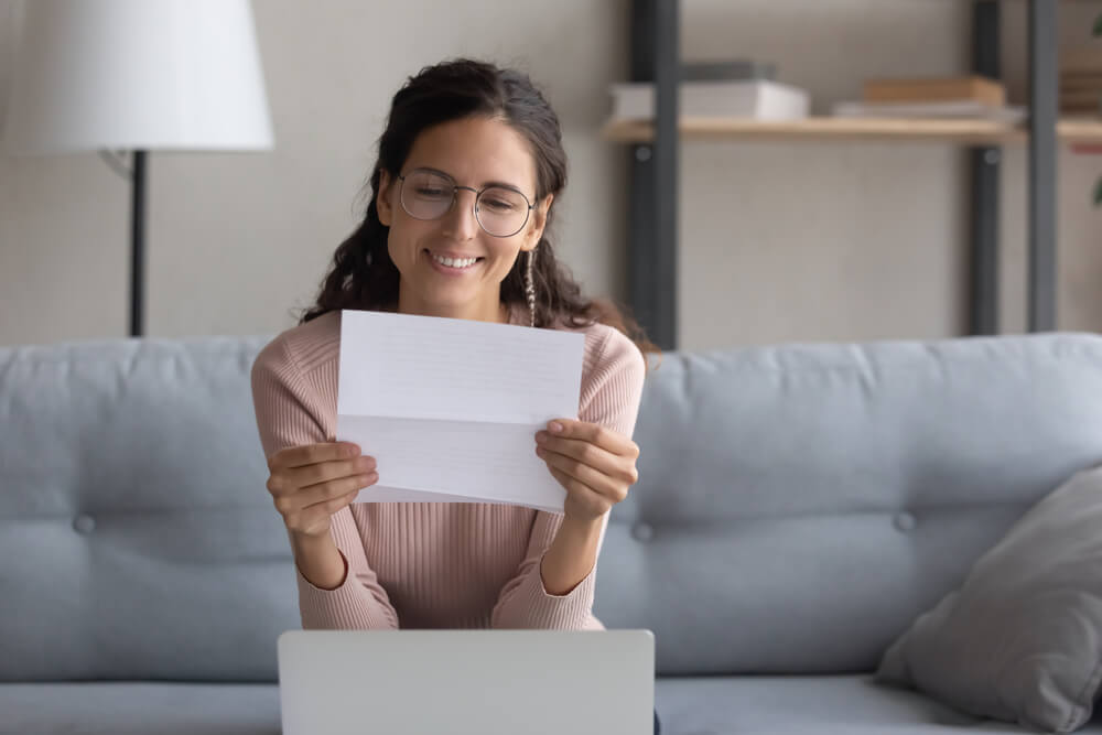 Smiling pretty female student reading paper