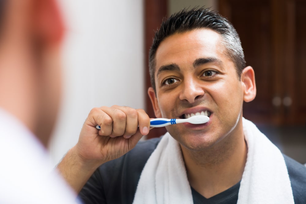 man brushing the teeth