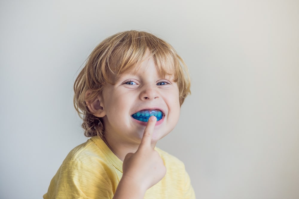 little boy shows myofunctional trainer to illuminate mouth breathing habit