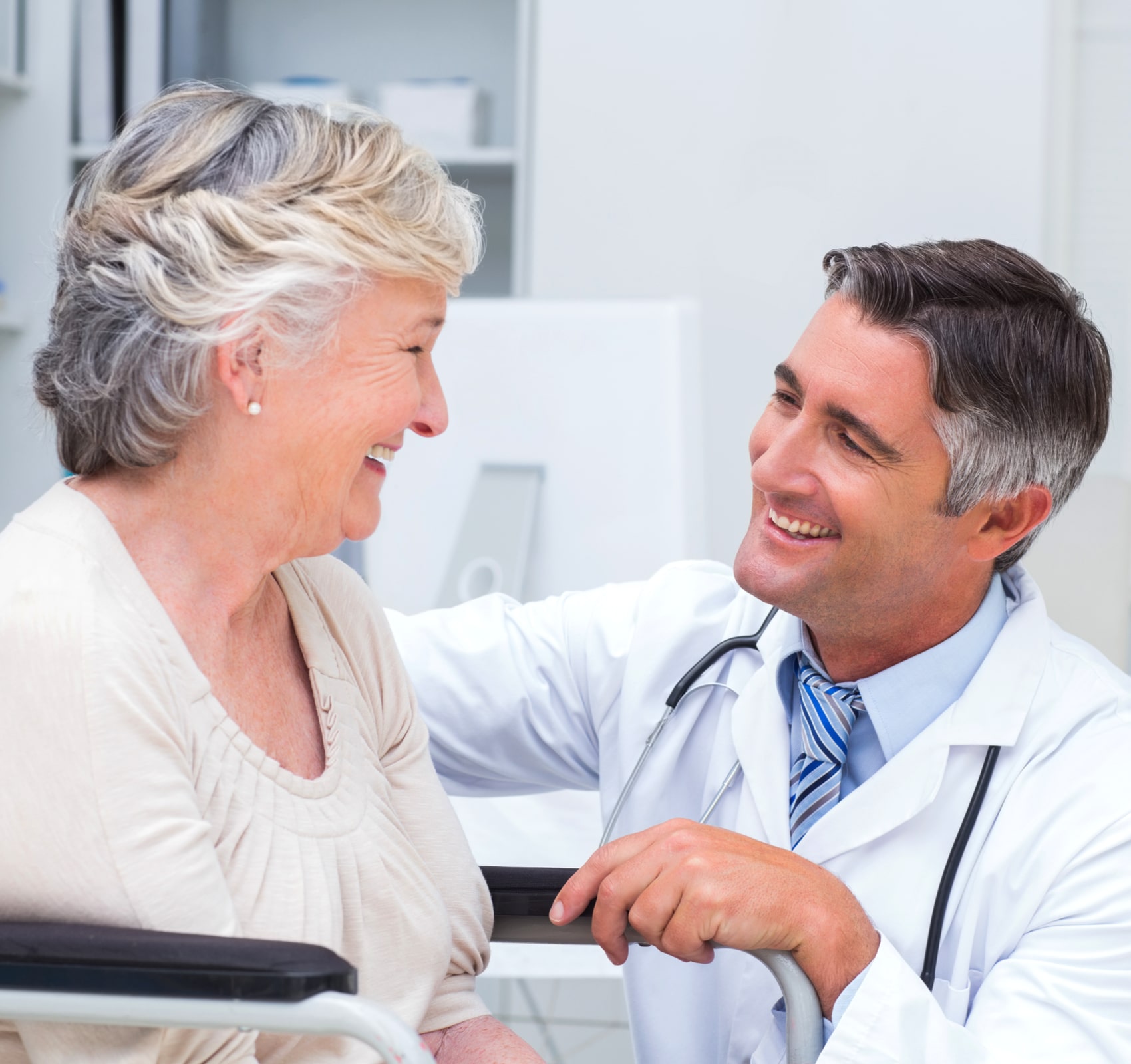 Happy male doctor looking at female patient