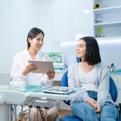 dentist holding digital tablet and giving consultation