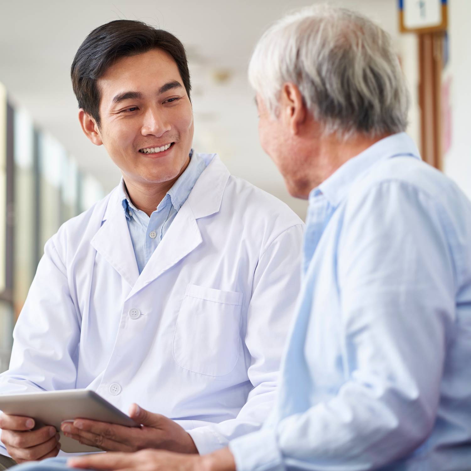 smiling young doctor with elderly patient