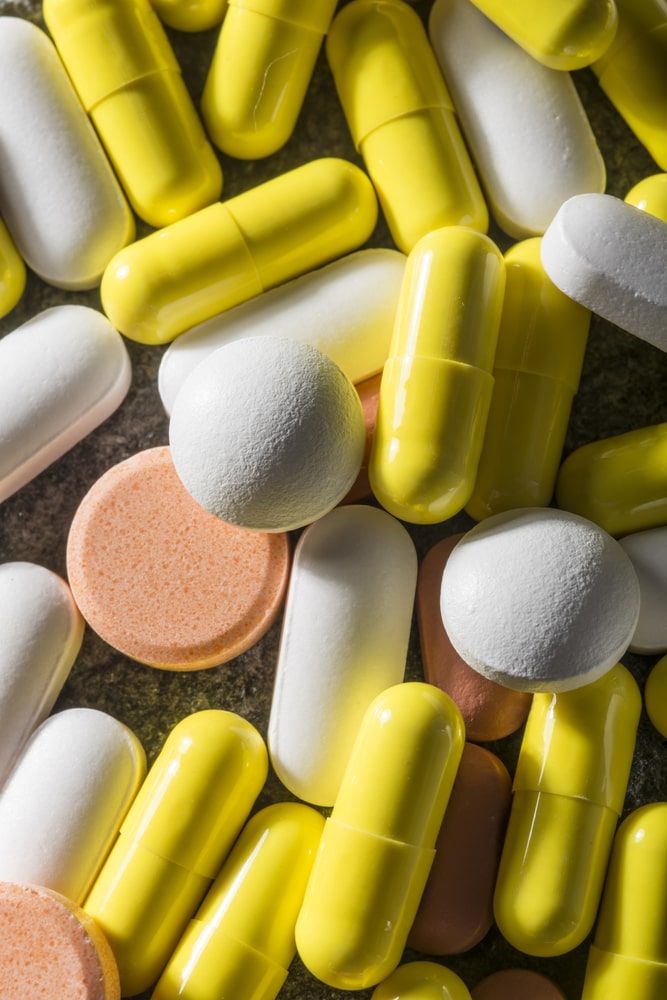 assorted yellow, orange, and white pills